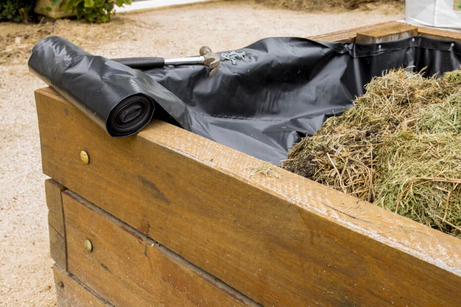 liner fabric sticking out of raised garden bed